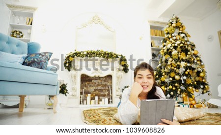 Business Beautiful Young Girl, Successful Businessman Talking on Skype With Staff and Congratulates, Covers All Important Business Matters and Business Before New Year Lying on Rug in Bright Room on