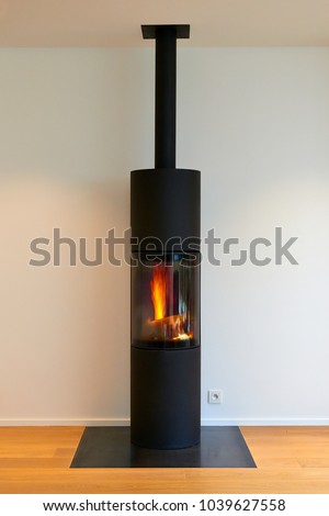 Modern metal fireplace with flamme against white wall