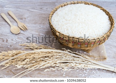 Thai jasmine rice in wooden bowl on wood background
