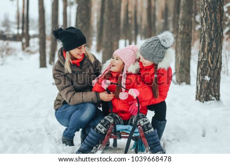 mother with her children playing in the winter forest