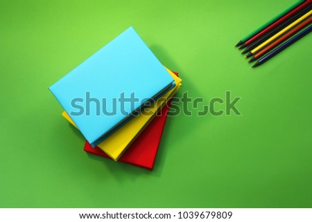 office working space. books in colored wrappers on a green background. stationery.  pencils. Royalty-Free Stock Photo #1039679809