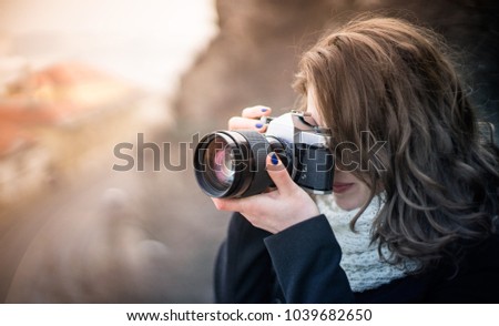 Young woman girl photographer with blue camera lens