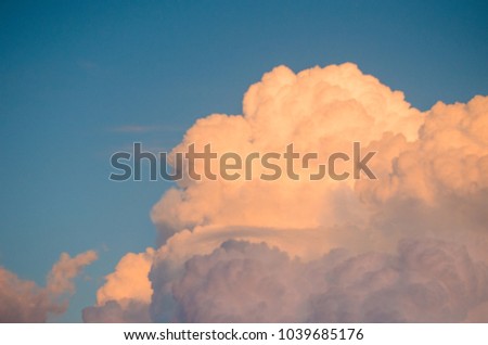 Photograph of some clouds with the sunset creating a red-orange color.