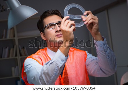Construction architect working on drawings late at night
