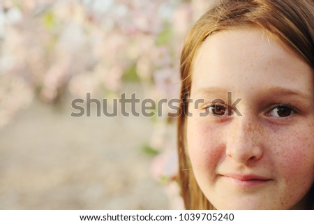 close up portrait of teen girl walking on rural blossom park