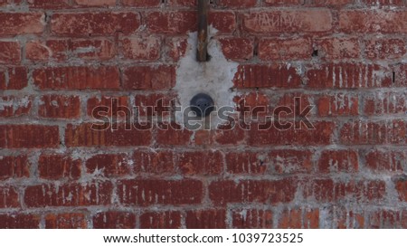 Brick wall with electrical outlet.