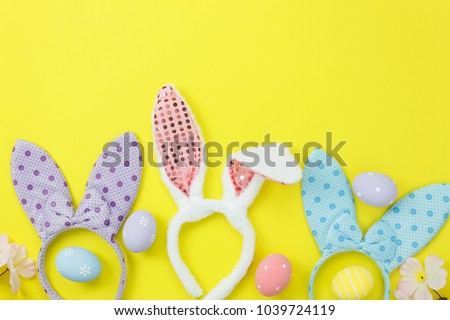 Top view aerial image of decoration & symbol Happy Easter holiday background concept.Flat lay accessory costume bunny ear and eggs paint on modern beautiful pink paper at home office desk with space.