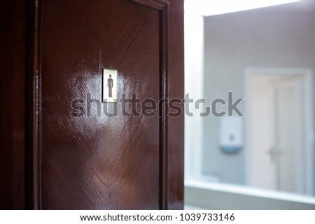 Men toilet sign on a wooden door