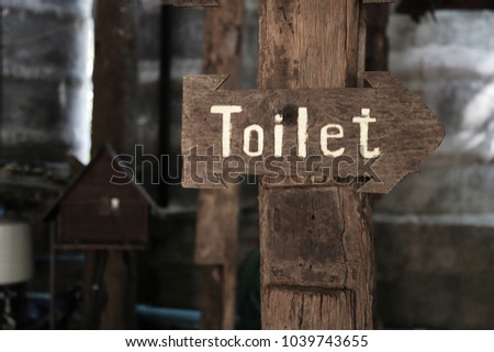 A classic simple design handmade wooden sign of toilet give direction to WC.