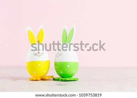Two funny easter bunnies on pink background with copy space