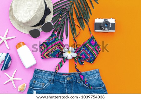 Summer Fashion woman swimsuit Bikini, camera, starfish, sunblock, sun glasses, hat. Travel and vacations in the holiday, purple and pink color background. Summer Concept.
