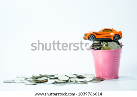Full coins in pink bucket with coin money and car toy on white background