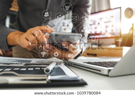 designer man using smart phone for mobile payments online shopping,omni channel,sitting on table,virtual icons graphics interface screen in morning light
