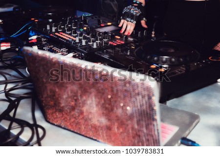 DJ mixes tracks at a party. DJ control panel