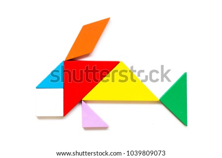 Color wood tangram puzzle in swimming fish shape on white background