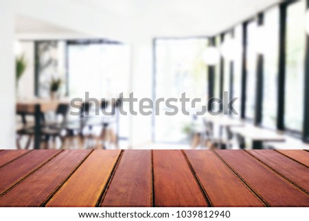 Empty wooden table and blurred background of abstract in front of restaurant or coffee shop for display of product or for montage.