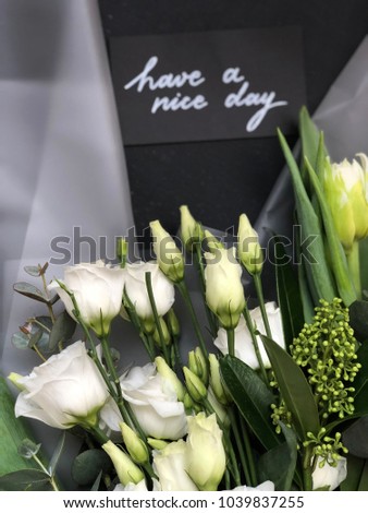 have a nice day card with flowers. black card with white text have a nice day and flowers 
