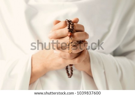 Praying monk with rosary beads, closeup Royalty-Free Stock Photo #1039837600