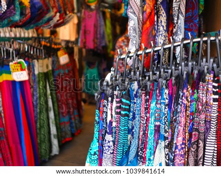 Hanging colorful Bohemian-style skirts in a shop at Jatujak market (JJ market) in Bangkok, weekend market shopping, The Thai words appear in the price tag means "Discount or Sales"