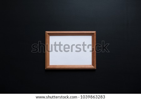 wooden frame for photos on a black matte surface background