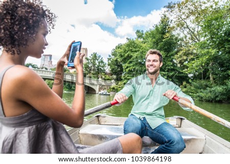 Happy couple having fun on a boat in Central Park - couple taking a picture while sightseeing Manhattan