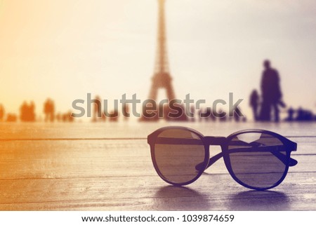 Glasses on wooden table with Eiffel tower on background 