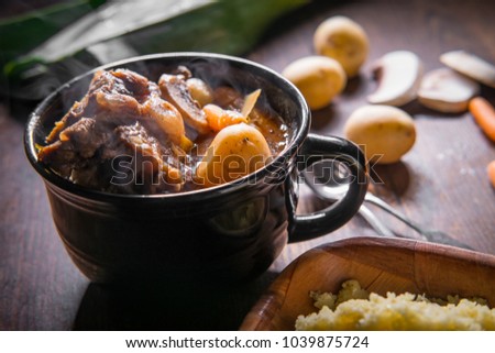 Potjiekos South African oxtail stew with baby gold potatoes carrots and button mushrooms Royalty-Free Stock Photo #1039875724