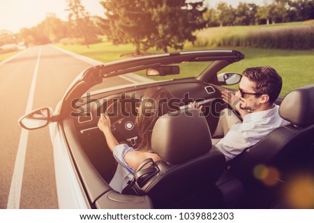 Friends, friendship, destination, auto vehicle rent, escape, speed ride. Rear back shot of carefree wife driver with arms rudder and henpecked husband on way to honeymoon, sunshine, sunlight, light Royalty-Free Stock Photo #1039882303