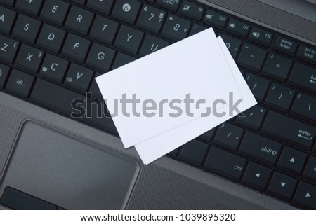 Laptop and business cards, white cards are used for business.
