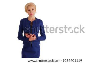 Businesswoman texting on cell phone stopping to look at camera in studio 