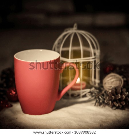 closeup.red Christmas Cup and the candle on the holiday table