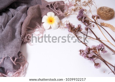Cloth and dried flowers placed on white paper.