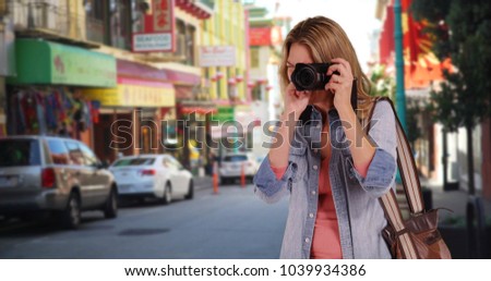 Cheerful woman sightseeing and taking pictures in Chinatown San Francisco