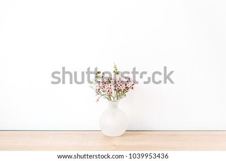 Wild flowers in front of white wall. Minimal.