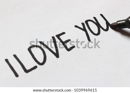 Marker writes on paper word i love you