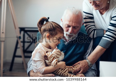 Grandparents playing with their granddaughter Royalty-Free Stock Photo #1039988164