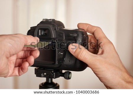Closeup of male hand inserting bank card into camera, concept