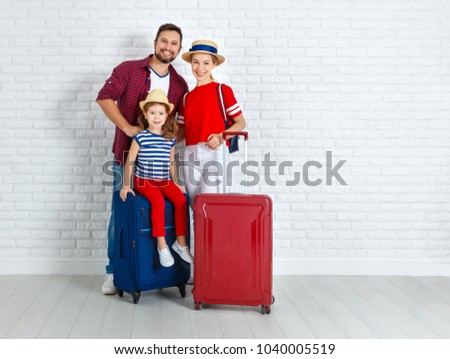 concept travel and tourism. happy family with suitcases near empty wall
