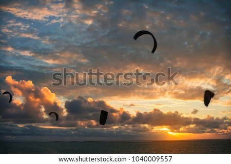 Kitesurfing at sunset, kite silhouette against the beautiful sky background