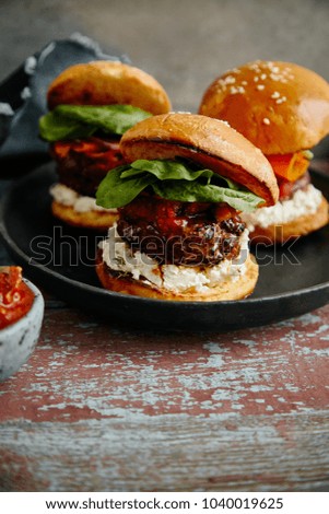 Burgers with grilled beef patties, cream cheese and spinach on classical bun. 