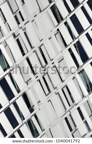 Reworked photo of windows on an office building facade. Black and white image in a concept of modern architecture and construction industry. Abstract technological background.