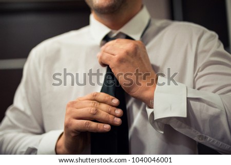 A businessman dresses and clings his clothes and jewels Royalty-Free Stock Photo #1040046001