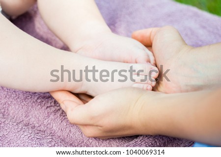 Baby feet in mother hands. Tiny newborn baby feet, concept of happy family. Fake color tone of photo

