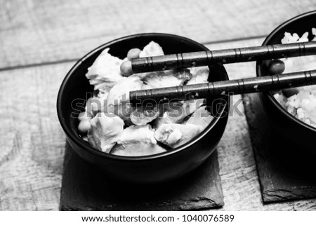 Chinese rice bowl on wood or wooden background with chopsticks black and white photo photography