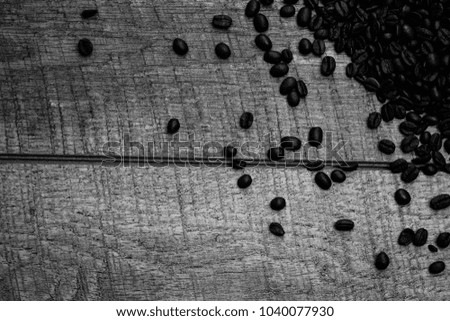 Coffee beans on wood table suitable as a background texture or wallpaper black and white photography