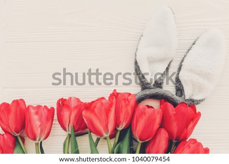 bunny ears and stylish pink tulips on white wooden background flat lay. space for text. creative spring easter image. season's greeting card mock-up. happy easter concept