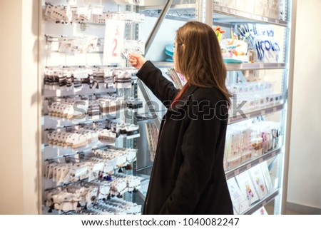 Woman consuming in a beautiful new shop of stationery buying and observing all the materials for sale in the bazaar