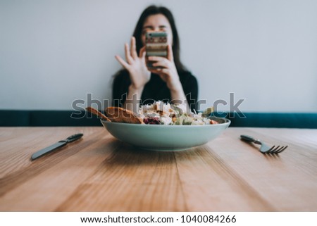 Woman taking food photo on smartphone camera