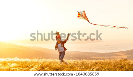 happy family father and child daughter run with a kite on meadow Royalty-Free Stock Photo #1040085859