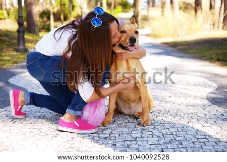 Outdoors lifestyle portrait of beautiful girl with a cute dog on
